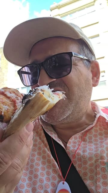 A creator visits a pizza street food stall in London during Pride, providing a personal recommendation and showing the product.
