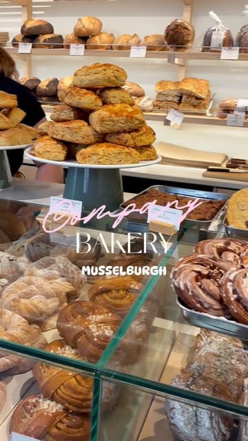 A vlog-style review of Company Bakery in Musselburgh, showcasing the cafe's interior, pastry selection, coffee, and behind-the-scenes pastry preparation.