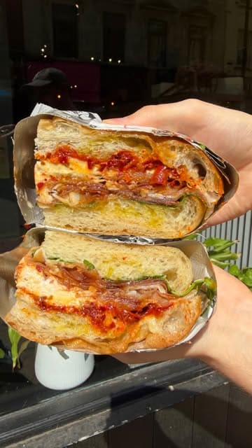 A fast-paced, enthusiastic review of Marleo Little Sicily in Manchester's Northern Quarter. The video features two creators sampling various Sicilian street food items, including arancini, focaccia sandwiches, and pastries, highlighting the quality and passion behind the food.