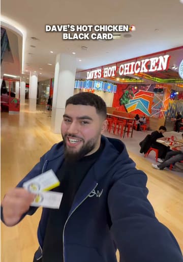 The creator visits a Dave's Hot Chicken location using a 'black card' to get free food. The video features a tour of the venue, a look at the menu, and a taste test of the sliders, fries, mac and cheese, and a cereal-topped milkshake.