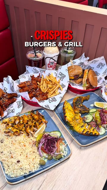 A promotional video for Crispies Burgers & Grill featuring a montage of their menu items including burgers, wings, grilled chicken, and drinks, interspersed with shots of the restaurant interior.