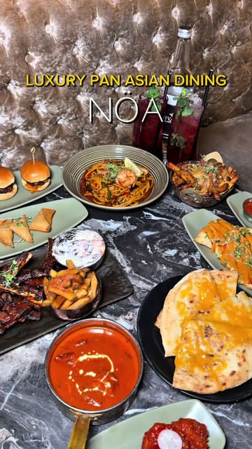 A promotional montage video for Nöa Lounge, featuring a variety of Pan-Asian and Indian-inspired dishes, cocktails, and desserts, set against the backdrop of the venue's stylish, neon-lit interior.