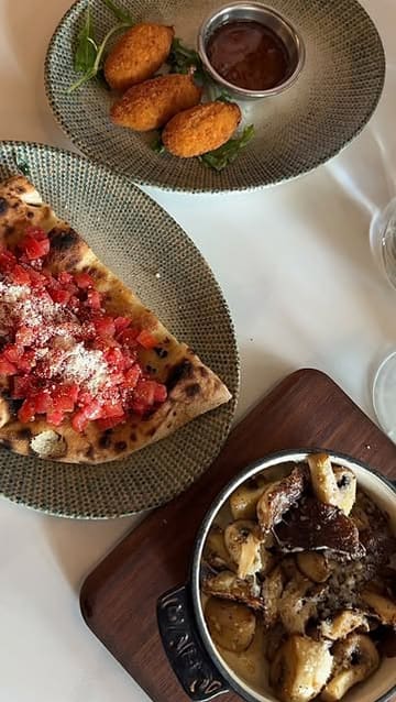 A montage video showcasing the interior and lunch menu at Aurelia in Aylesbury, featuring cocktails, various Italian dishes including pizza, pasta, and tiramisu.