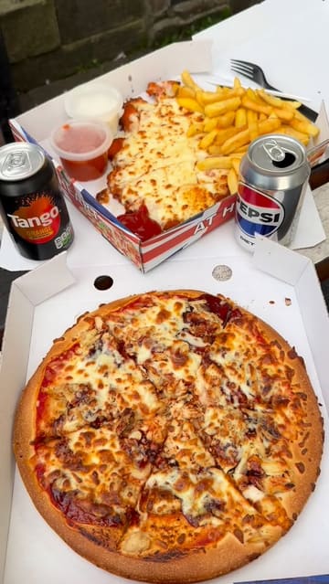 A short vlog-style review of a takeaway shop in Newcastle called Get Stuffed, featuring the creator walking up to the venue, showing the menu, and presenting the food (pizza and parmo with chips) in takeaway boxes.