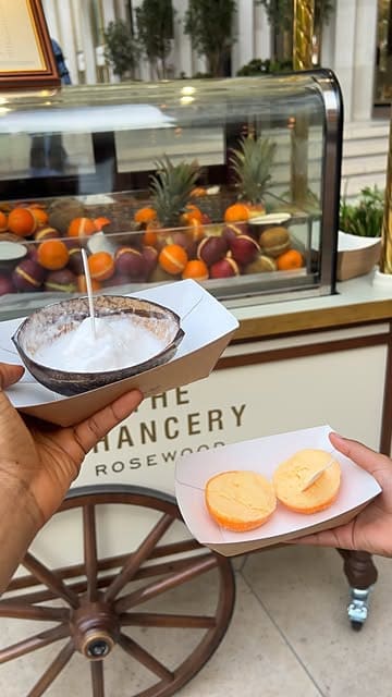 A short, handheld video showcasing a Fruttini pop-up cart located at The Chancery Rosewood, featuring close-ups of fruit-based desserts served in their shells.