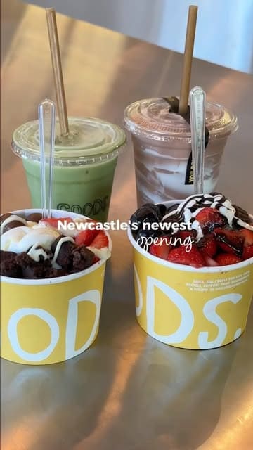 A montage-style venue tour of a new cafe and organic grocer called GOODS in Newcastle. The video highlights the interior, the coffee and matcha drinks, various food items like wraps and frozen yogurt, and the retail section including fresh produce and flowers.
