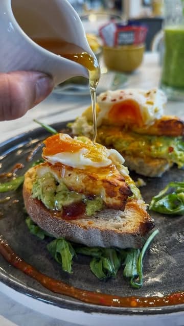 A short, punchy reel showcasing a brunch spot called Ella's of Davenham. The video features a montage of various brunch dishes, including avocado toast with a poached egg, a green smoothie, coffee, and a brownie, alongside shots of the cafe's interior and exterior signage.