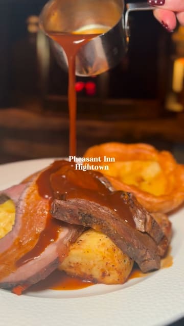 A montage-style video showcasing a Sunday lunch experience at the Pheasant Inn in Hightown. The video features close-up shots of various dishes including scallops, roast beef, fish and chips, and desserts, alongside shots of the cozy interior and drinks.