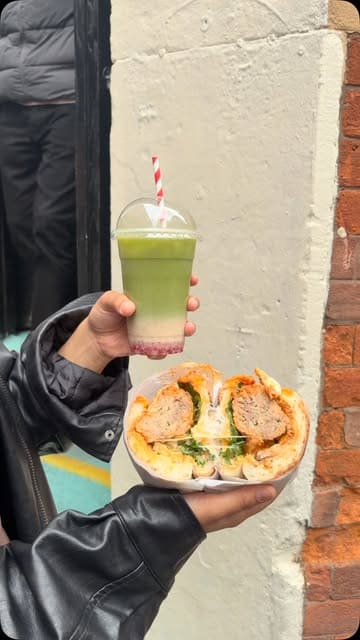 A short, fast-paced video showcasing the preparation and final presentation of a loaded meatball sandwich and a green drink at a Manchester-based sandwich shop.