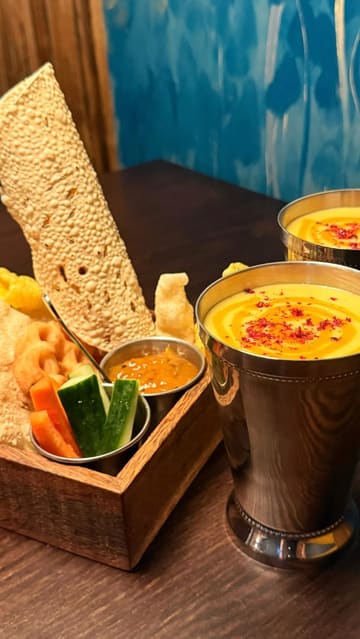 A couple visits Dhamroo in Oxford, showcasing the interior, menu, and a variety of Indian dishes including chilli paneer, chicken 65, prawn curry, beef curry, and traditional desserts.