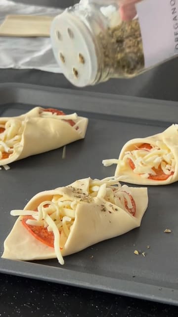 A short, instructional video demonstrating how to make pepperoni and cheese turnovers in an air fryer, featuring a clear step-by-step process from assembly to the final cheese pull.