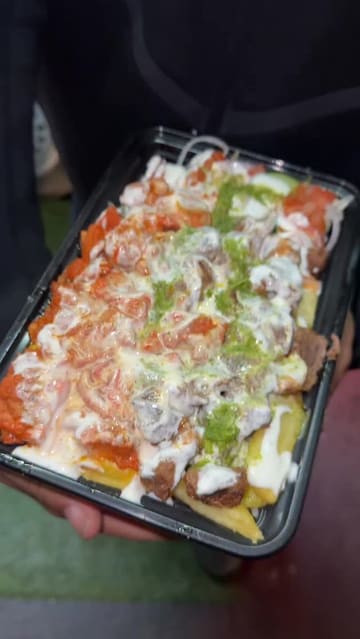 A creator visits a street food truck called Suff's Halal in Birmingham, sharing a personal anecdote about the owner before reviewing their chicken and lamb over rice dish.