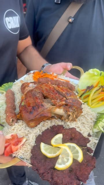 Two creators review food from Tahir Khan Restaurant in Birmingham, specifically trying a lamb leg 'dampukht' platter and a chicken tikka curry.