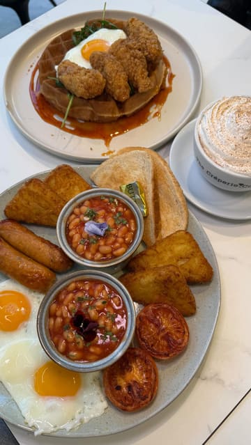 A montage video showcasing the interior and menu items at The Crêperie Co, featuring close-ups of hot drinks, a full English breakfast, chicken and waffles, and French toast.
