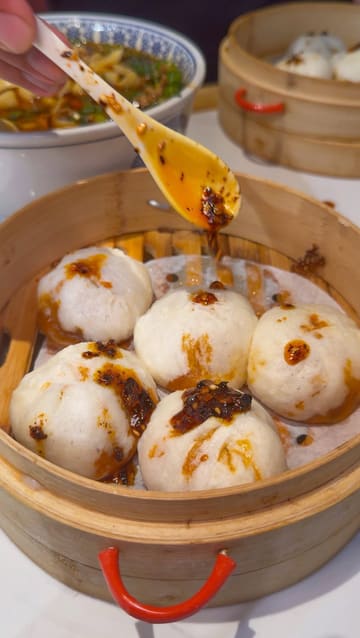 A food review video featuring a visit to Mr. Dumpling in London. The creator showcases a variety of handmade dumplings, including spicy beef, prawn, pork, and chive, as well as potstickers and hand-pulled noodle soups. The video uses close-up shots to highlight the texture and preparation of the food, accompanied by the creator's enthusiastic commentary.