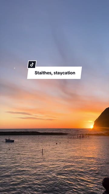 A travel-style montage showcasing a weekend trip to the coastal village of Staithes. The video features scenic shots of the beach and sunset, interior shots of a cottage, a visit to a sweet shop, and glimpses of local dining at the Cod & Lobster.