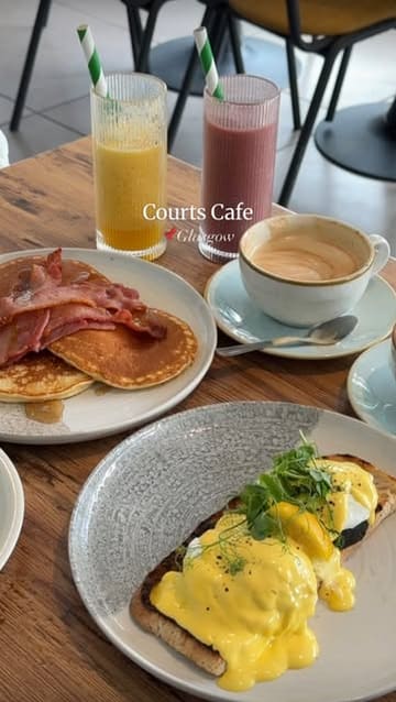 A review of Courts Cafe in Glasgow, highlighting its location inside a sports club and its affordable all-day breakfast menu, including eggs benedict and pancakes.