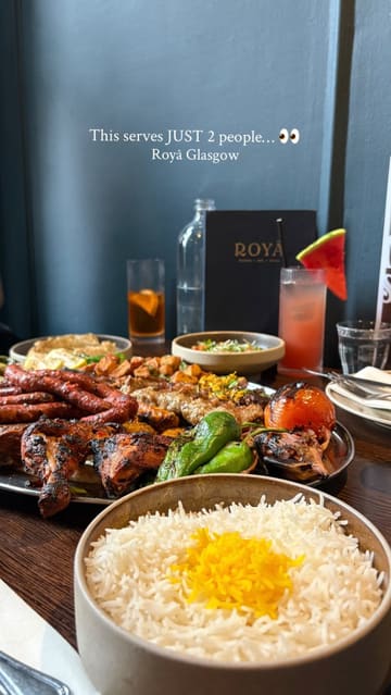 A short, polished montage showcasing a large 'Mangal' sharing platter at a restaurant called Roya. The video highlights the variety of meats, sides, and dips included in the meal, emphasizing its suitability for sharing.
