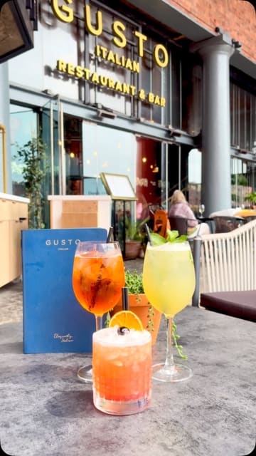 A promotional montage showcasing the summer menu and terrace area of Gusto Italian. The video features close-ups of cocktails, pizza, steak, and scallops, interspersed with shots of the restaurant's interior and outdoor seating area at the Albert Dock.