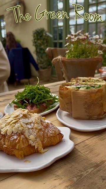 A montage video showcasing 'The Green Room' cafe, highlighting its bright interior, outdoor seating, live music, and a selection of food and drinks including focaccias, open sandwiches, and pastries.