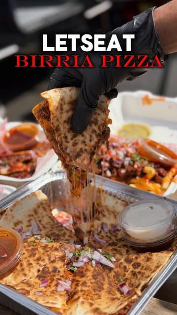 A short, high-quality food showcase featuring a birria pizza being pulled apart and dipped into consommé, followed by a shot of the 'Let's Eat' food truck.
