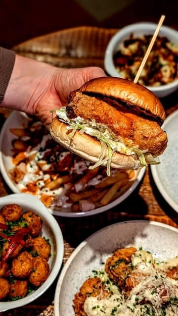 A promotional reel showcasing a new fried chicken residency at The Suffolk Arms, featuring close-ups of various chicken dishes, loaded fries, and sides, set within the pub environment.