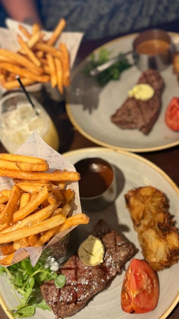 A video tour of a Miller & Carter steakhouse, featuring shots of the restaurant interior, the menu, and a meal consisting of calamari, rump steak with fries and onion loaf, and cocktails.