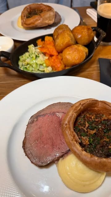 A montage video showcasing a Sunday roast experience at Thomas, The Brasserie in Cardiff, featuring close-ups of the roast beef, starters, desserts, and cocktails.