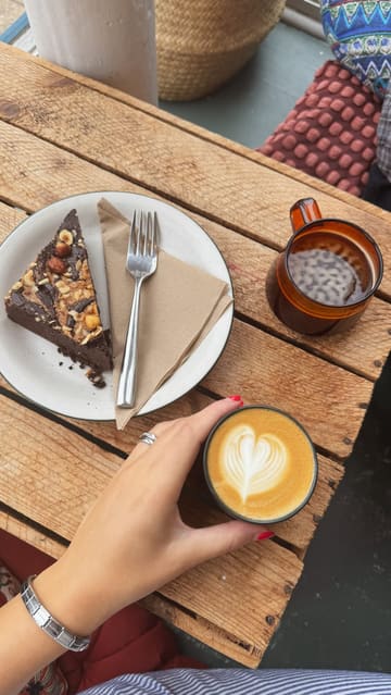 A short, aesthetic reel showcasing a visit to a combined coffee shop and bookshop in Portobello. The video features shots of the exterior, the interior book-lined walls, and a close-up of a latte and a slice of cake, emphasizing the cozy, peaceful atmosphere of the venue.