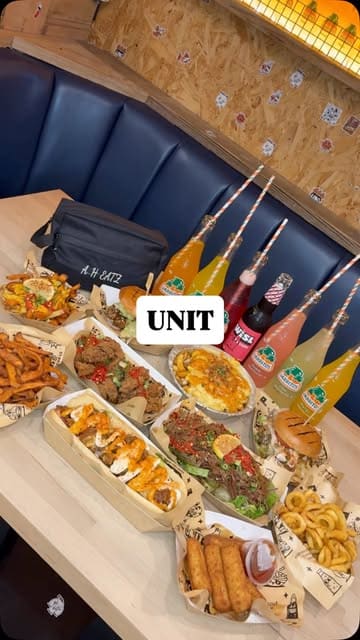 A fast-paced montage showcasing a variety of burgers, loaded fries, tenders, and salads at Unit in Sheffield, accompanied by branded sodas. The video features close-up shots of food preparation and presentation, highlighting the menu's comfort food appeal.