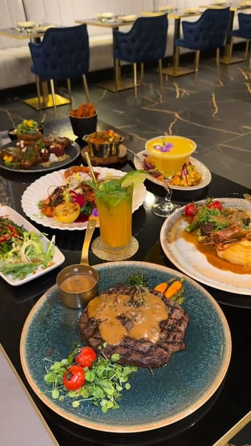 A high-quality, visually focused montage showcasing the premium steakhouse offerings and elegant interior of AVA Grill. The video features slow-motion close-ups of various dishes, including steaks, grilled prawns, and desserts, alongside shots of the restaurant's modern, spacious dining area.