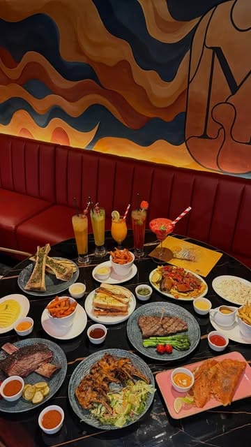 A montage of various meat dishes including steak, lamb chops, brisket, and bone marrow, presented at a modern steakhouse venue. The video focuses on the food presentation and the stylish interior of the restaurant.
