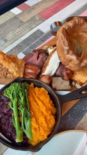 A promotional video for 'On the Water' restaurant in Lee-on-the-Solent, showcasing their Sunday roast sharing platter, sides like mac and cheese and truffle roast potatoes, and a dessert, while highlighting the restaurant's coastal views and cozy atmosphere.