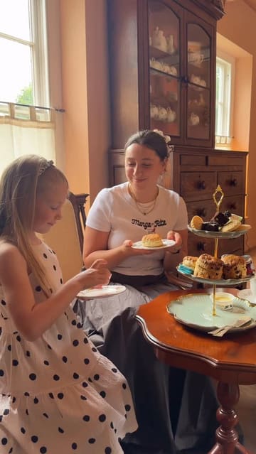A short, pleasant video documenting a family visit to a cafe for an afternoon tea service. The footage captures the arrival, the table setting, the tea pouring, and the enjoyment of the scones and sandwiches.