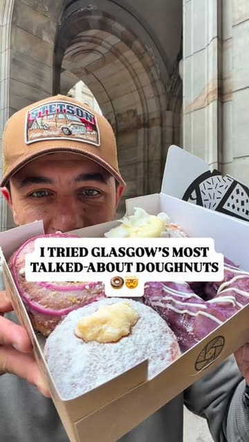 A creator visits Tantrum Doughnuts in Glasgow, showcasing the shop's display and tasting four different doughnut varieties: Pistachio & Hibiscus, Blueberry & White Chocolate, Brazilian Lemonade, and Tropical Curd. The video is a fast-paced, enthusiastic review that highlights the quality and variety of the doughnuts.
