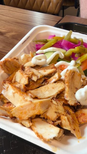 A short, montage-style video showcasing a visit to Babtooma Express in Darley Street Market. The video features shots of the market exterior, the food stall, and close-ups of Syrian street food dishes including chicken shawarma, arayes, fries, and salad, accompanied by soft drinks.
