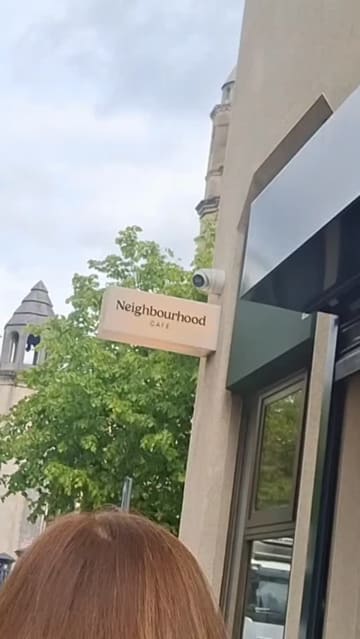 A short vlog-style review of a visit to Neighbourhood Cafe in Belfast, featuring shots of the interior, the menu, and close-ups of the coffee, hot chocolate, whipped avocado toast, and a breakfast bagel.