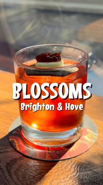 A montage-style reel showcasing a variety of cocktails and Japanese-inspired small plates at Blossoms in Brighton. The video features close-up shots of food preparation, finished dishes, and the venue's interior and outdoor seating area, set to music.