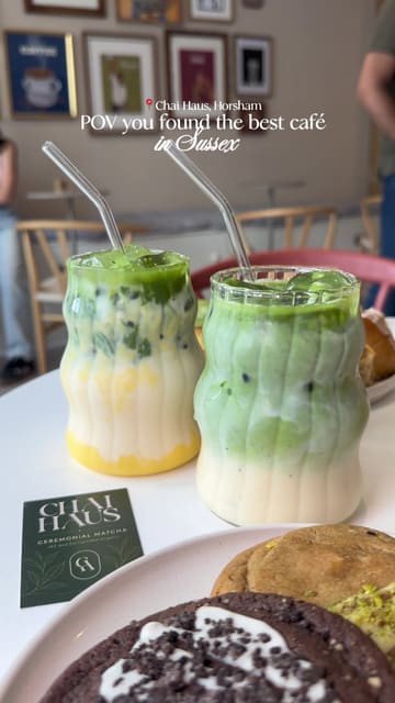A vibrant review of Chai Haus in Horsham, highlighting their Indian-fusion café concept. The video features a variety of items including ceremonial matcha drinks, authentic chai, homemade samosas, onion bhajis, and fresh bakes like cinnamon buns and cookies, set within an aesthetic and welcoming space.