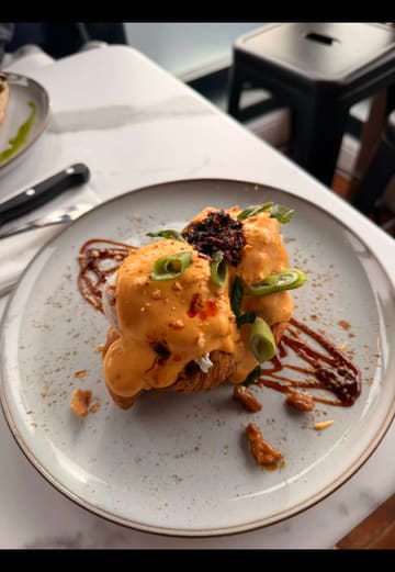A short, visually-focused montage showcasing brunch dishes and specialty lattes at Pickle & Peach in South Shields. The video features close-up shots of a duck-topped croissant, steak and eggs, and elaborately decorated iced coffees.