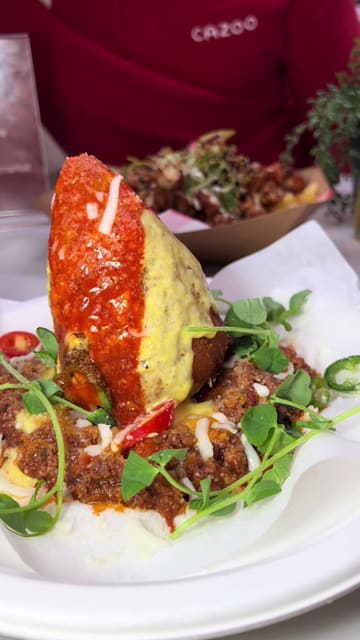 A couple visits Newport Market for a pre-match outing, showcasing a variety of food vendors including arancini, loaded fries, tacos, and burgers, followed by interactive darts.