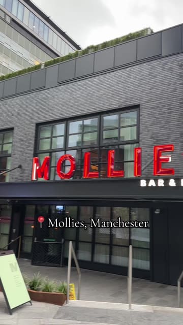 A short, vlog-style video showcasing a visit to Mollie's, an American-style diner in Manchester. The video features shots of the exterior, the interior, the menu, and various dishes including jalapeno cheese croquettes, chicken tenders, a lobster roll, a chicken burger, a cheeseburger, and fries, followed by a group toast with drinks.