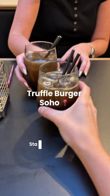 A vlog-style review of a visit to Truffle Burger in Soho, London, showcasing a variety of menu items including drinks, chicken tenders, caesar salad, mozzarella sticks, carnival onions, and burgers.