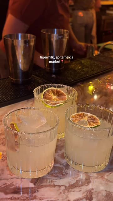 A short, energetic montage showcasing the atmosphere, cocktails, and entertainment at Tigermilk in Spitalfields. The video highlights the venue's distinctive backlit bottle wall, live mariachi music, and social dining experience.