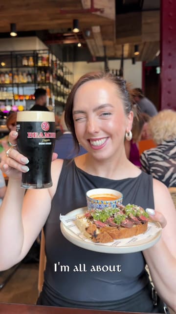 A creator visits Daffodil Mulligan in London, highlighting its Irish ownership and showcasing a variety of dishes including a steak sando, fried chicken, and cocktails, while promoting their lunchtime offer.