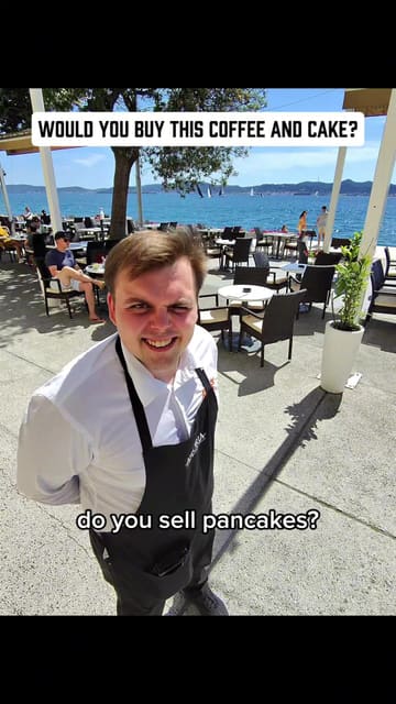 A first-person vlog review of a cafe located by the sea in Croatia. The creator interacts with the waiter, orders a 'Snicker Premium' dessert, a cappuccino, and an orange juice, providing an honest assessment of the value and quality.