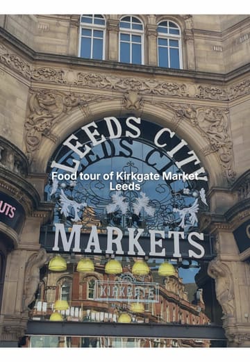 A fast-paced vlog-style video featuring two creators touring various food vendors at Leeds Kirkgate Market, highlighting specific dishes and prices at stalls like Tasty Shawarma, Bánh & Mee, Pollini’s, The Teapot, Seoulful Bites, Karpaty Bakery, and Mr Mackerel.