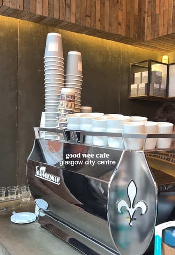 A short, handheld-style video showcasing Laboratorio Espresso in Glasgow city centre. The video features quick cuts of the coffee machine, menu board, cake display, interior seating, and a close-up of a slice of carrot cake being eaten, ending with a shot of the exterior.