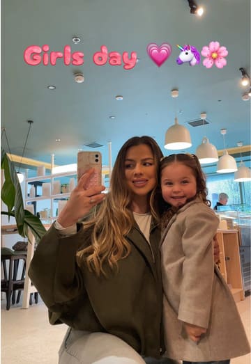 A 'day in the life' vlog featuring a mother and daughter spending time together. The video includes making protein pancakes at home, playing with a toy, dropping off the father, playing pickleball, shopping, and visiting a cafe called Jukō for an açai bowl and matcha latte, followed by making pizza at home.