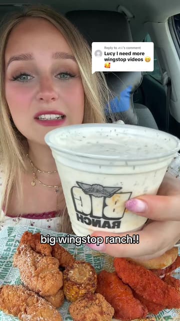 A creator reviews Wingstop food items, specifically focusing on the new large ranch dip, while sitting in a car. The video features close-ups of various menu items like tenders, a burger, fries, and corn being dipped and eaten.